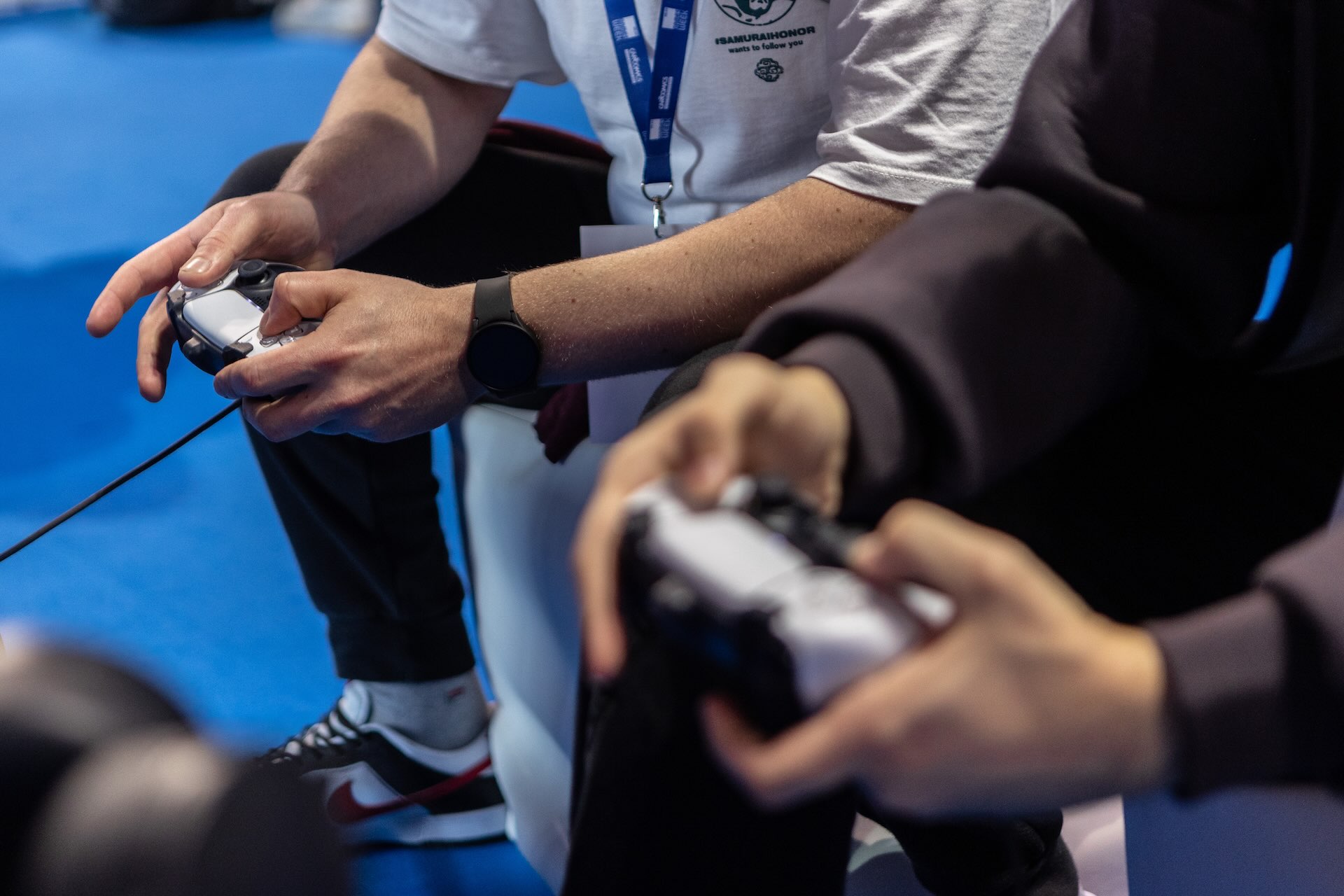 A close-up of the hands of two people holding video game controllers.