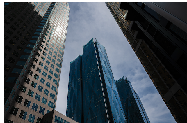 An image of tall buildings against a cloudy blue sky.